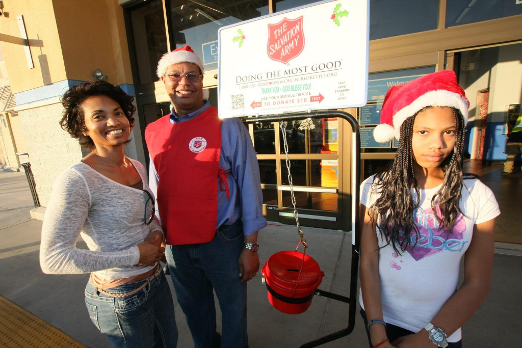 Salvation Army Board member Carl Dameron rings the bells with his family. Left to right: Malaika, Carl and Shaila. Photo by Ricard Tomboc