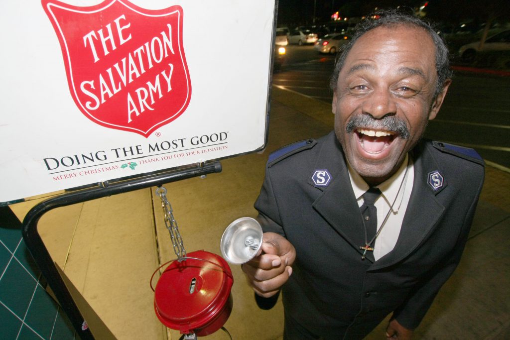 Photo 2 IMG_1652 Earl Perkins: Mr. Earl Perkins stands with his kettle by the entry doors at the Food 4 Less market on Victoria Ave. and Highland Ave. in San Bernardino. Earl is a Salvation Army Solider, and is in full uniform when he works. Earl has been with the Kansas City Salvation Army for over six years. Earl moved to San Bernardino four months ago, and is now a member of the San Bernardino Corps. Photo By Ricardo Tomboc 